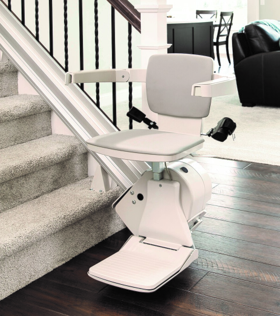 Real indoor straight chair lift beside a straight staircase; equipment example, not a local installation